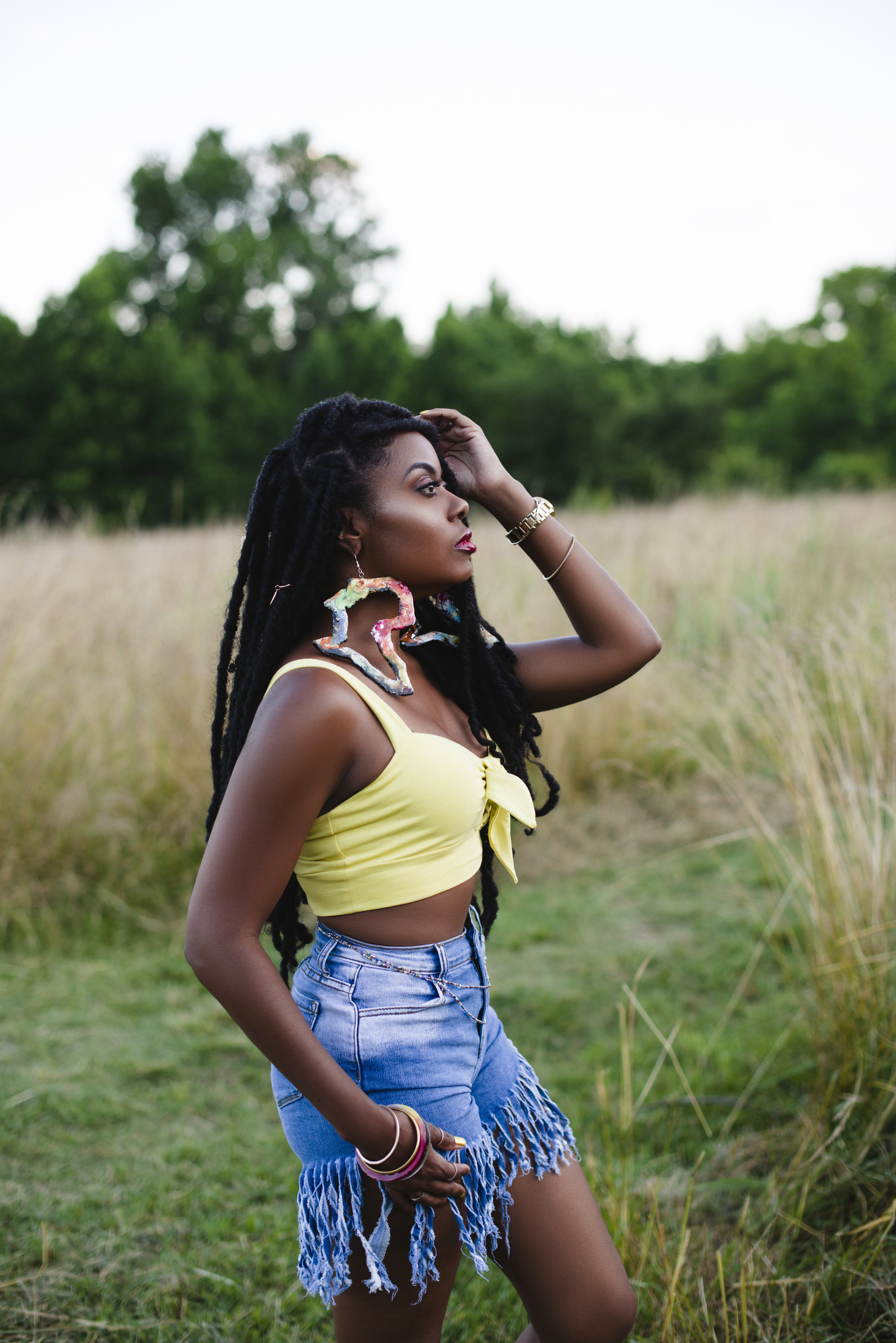 Standing in a golden field, hand resting in her hair