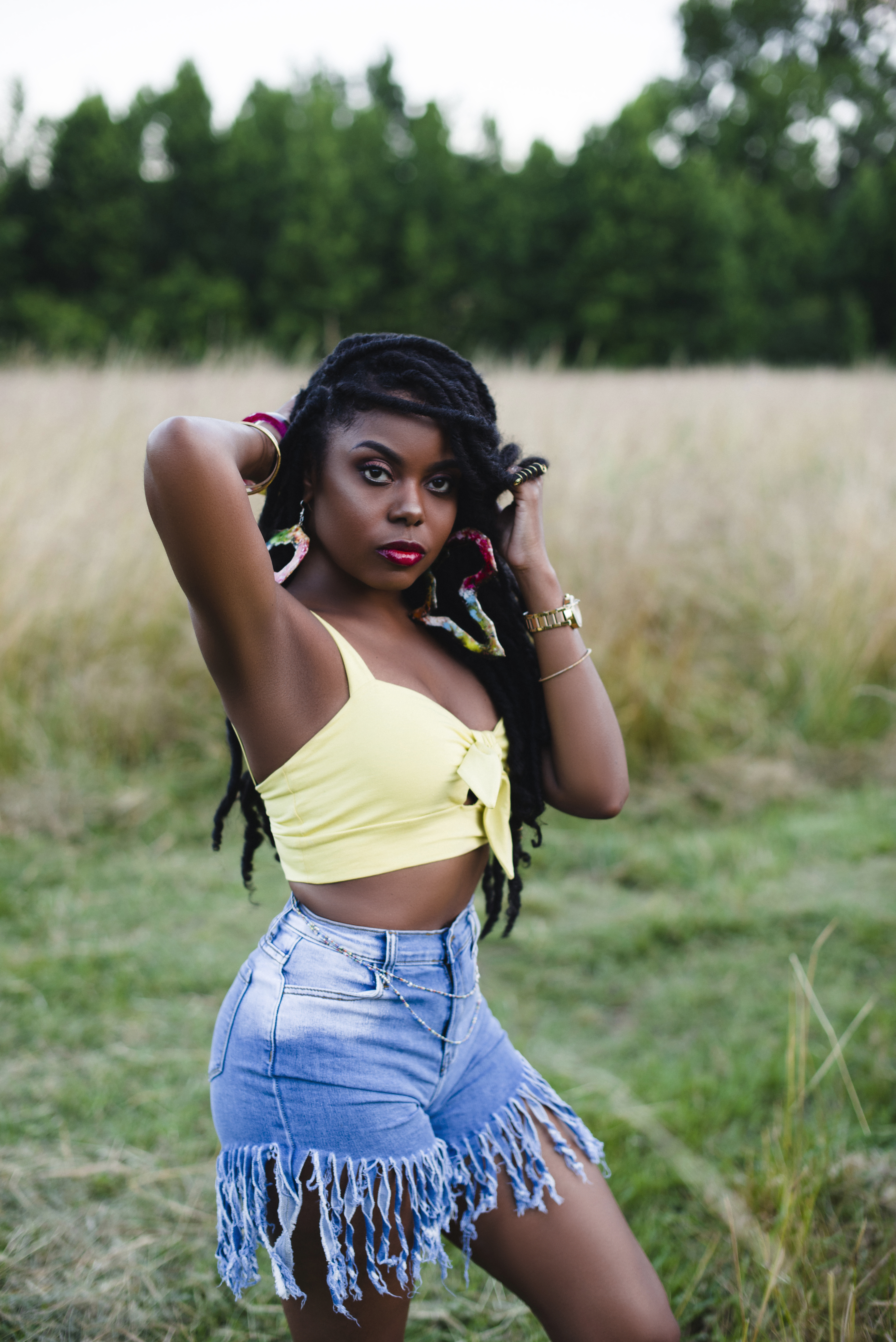 A close portrait in a summer field, hands framing the face