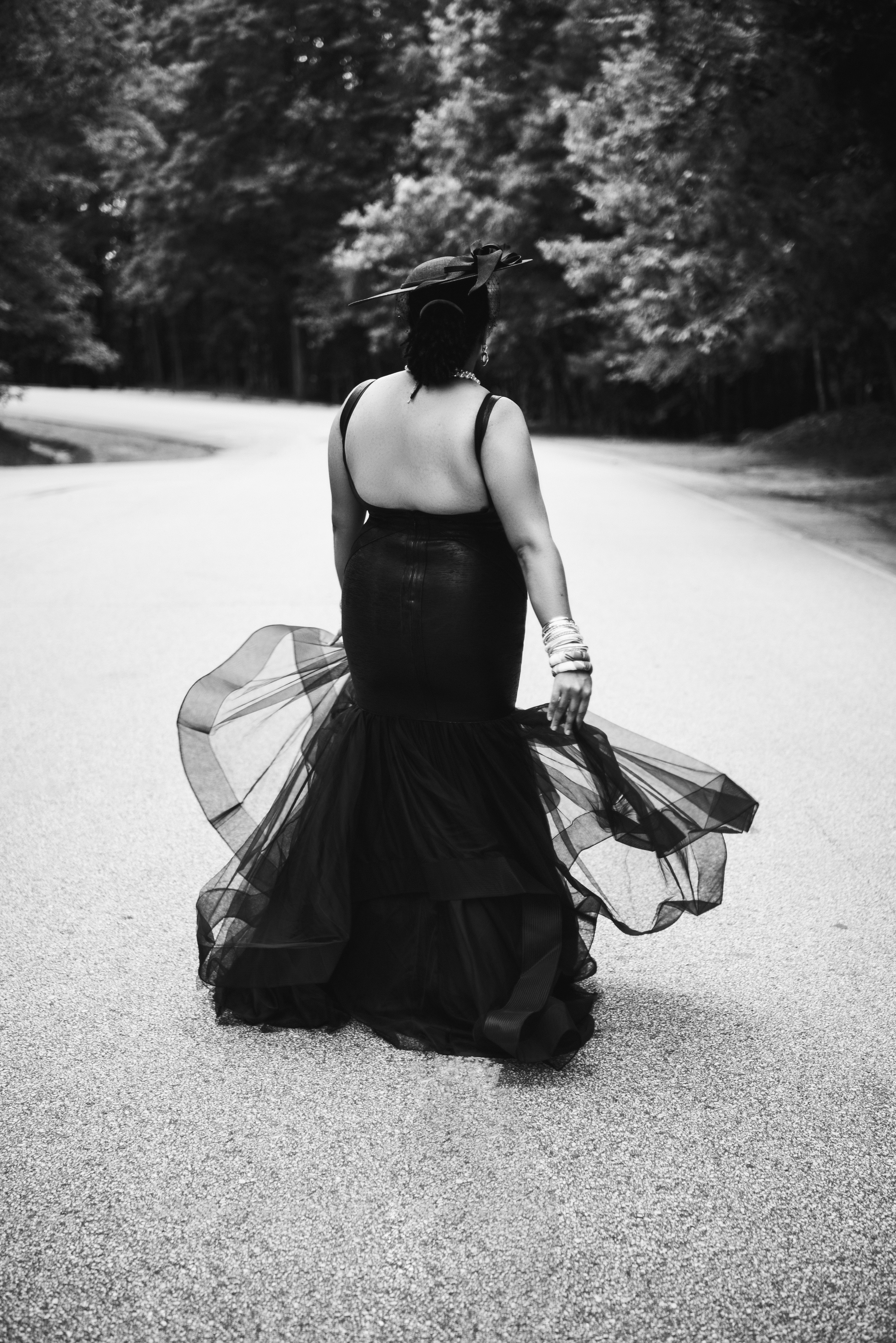 Black and white portrait from behind, the tulle skirt of a black dress swirling as she turns